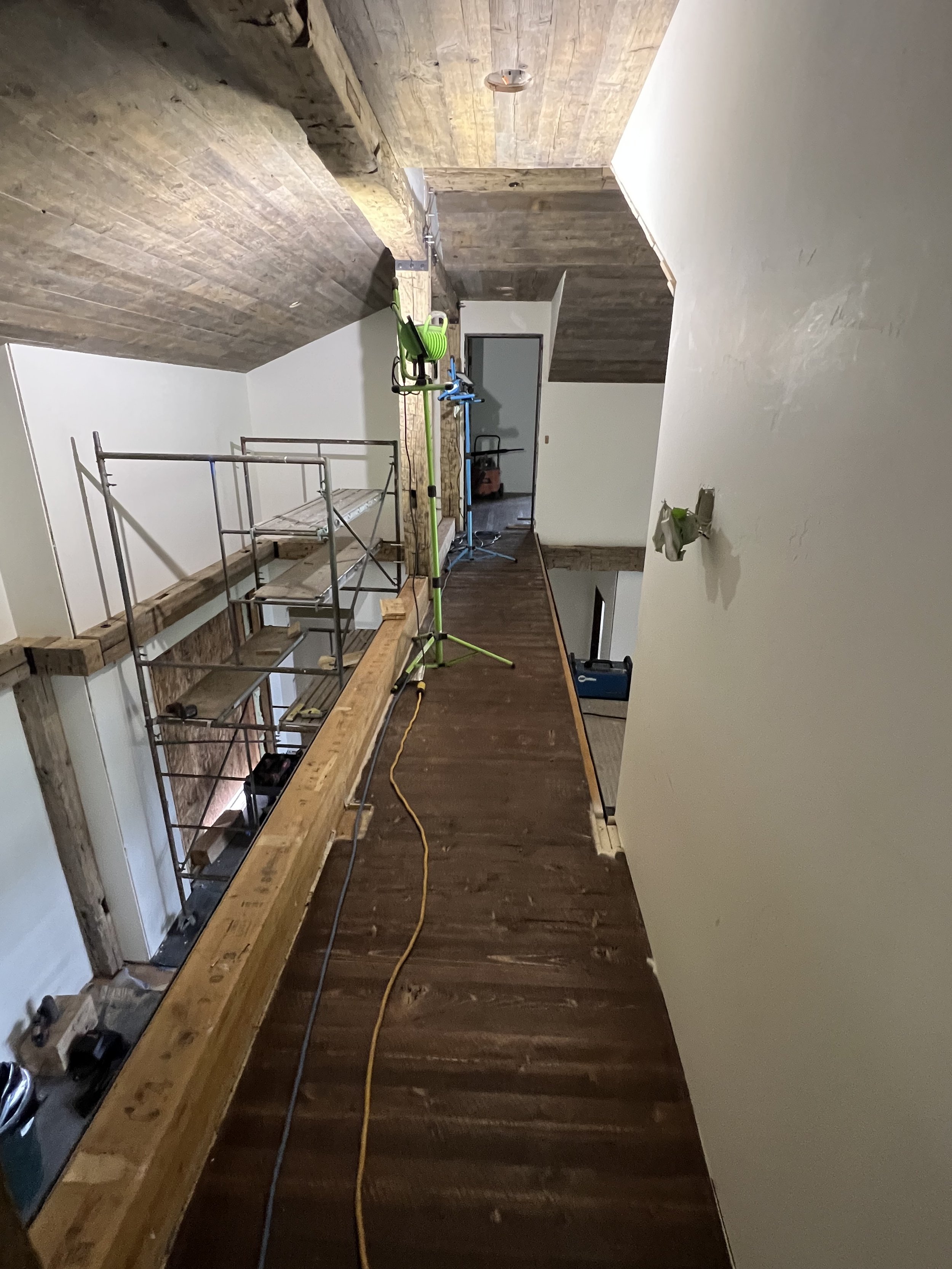 Interior loft renovation in progress with wood ceiling and scaffold.